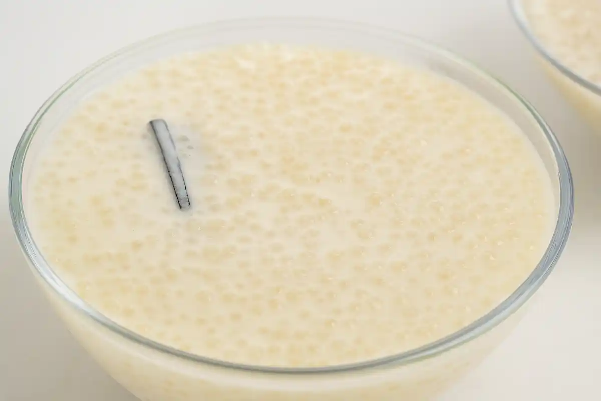 Tigela de vidro com sagu de leite cremoso, sobremesa caseira feita com leite, sagu, leite condensado e canela.