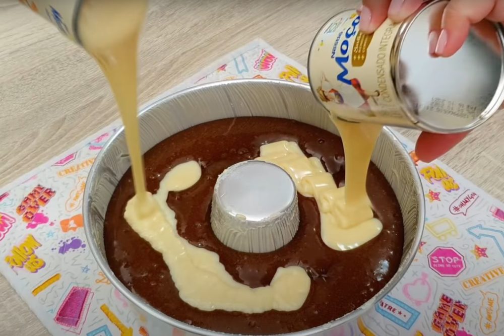 Despeje o leite condensado no bolo cru