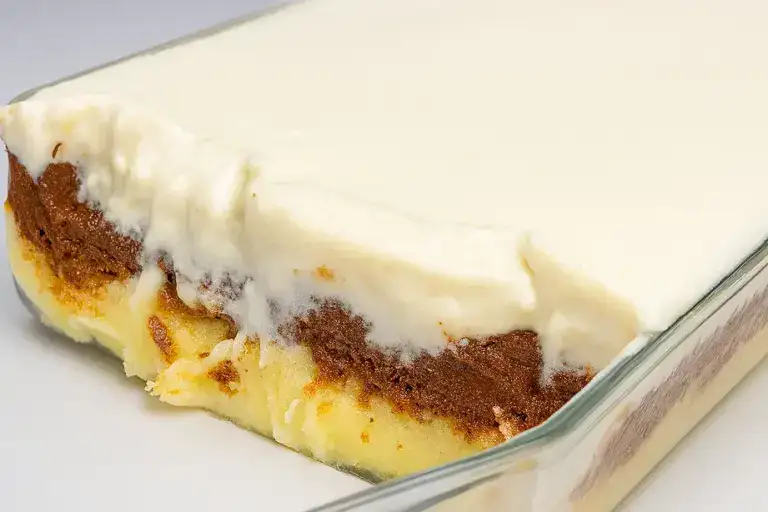 Sobremesa Beijo Gelado com camadas de creme branco, chocolate e base de massa macia servida em travessa de vidro