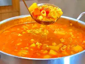 Sopa de macarrão com frango e legumes servida quente em prato fundo