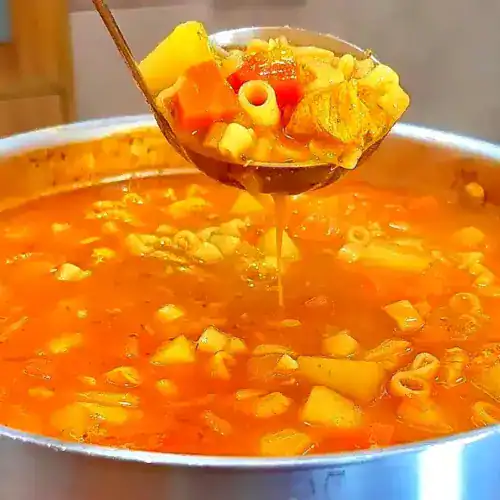 Sopa de macarrão com frango e legumes servida quente em prato fundo