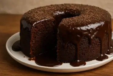 Bolo de chocolate molhadinho com calda brilhante em fatias